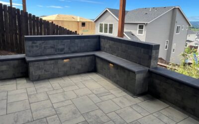 Paver Patio and Seat Wall in Beaverton, OR: A Level Patio Built Into the Slope Under a Deck, With a Seat Couch and Lit Side Yard Steps